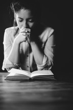 woman praying over a Bible 