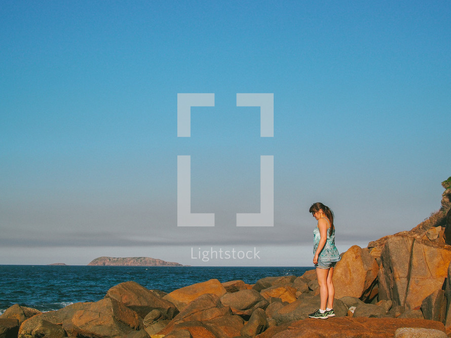 woman standing on rocks along Nelson Bay 