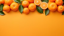 Oranges with leaves on orange background. Flat lay, top view