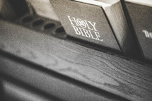 Bible in the back of a church pew.