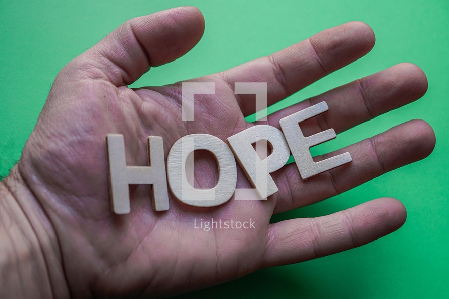 hope word on the hand on the green background