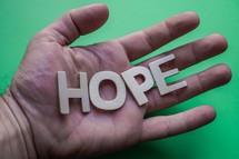 hope word on the hand on the green background