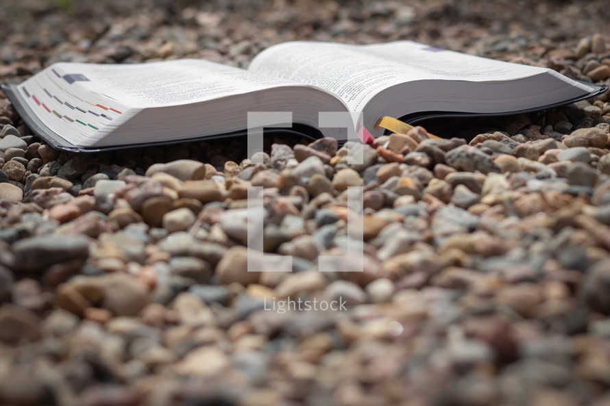 open Bible on pebbles