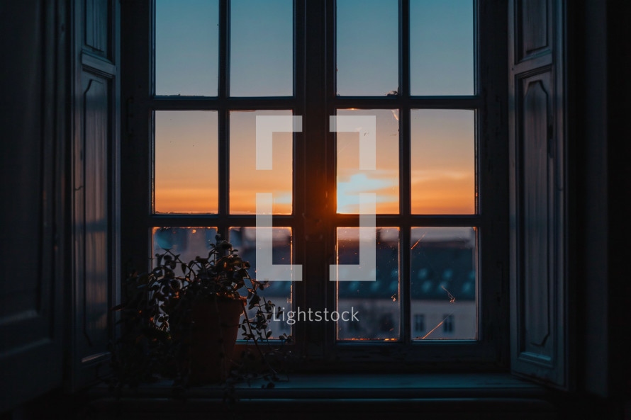 Old looking windows with the sun rising in the foreground