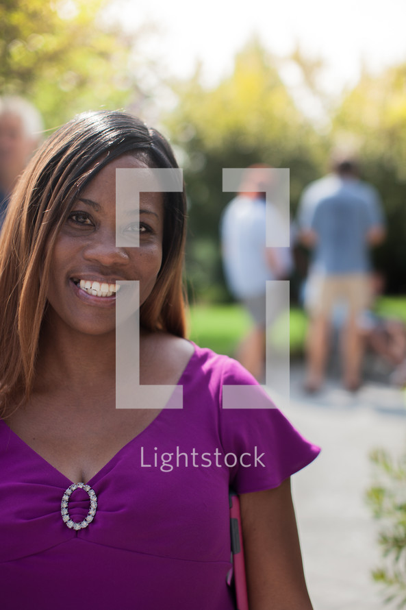 headshot of an African American woman and friends talking at a backyard summer party