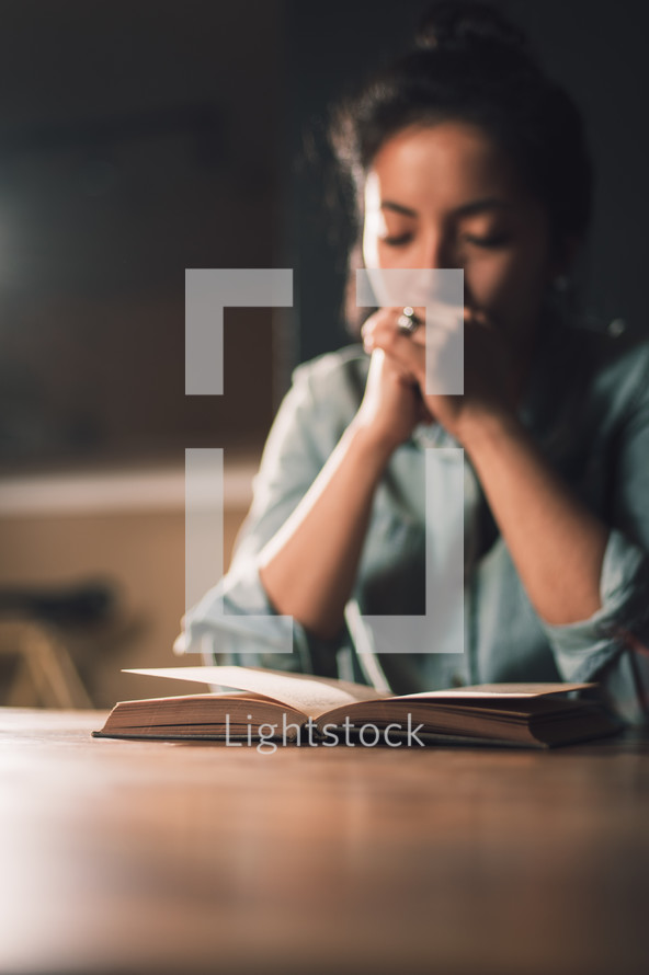 woman praying over a book 