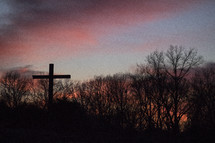 cross under a pink sky at sunset 