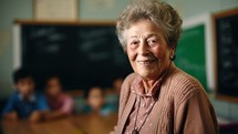 Portrait of smiling senior teacher sitting in classroom