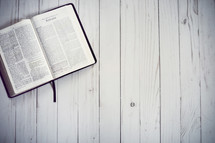 open Bible on wood background 