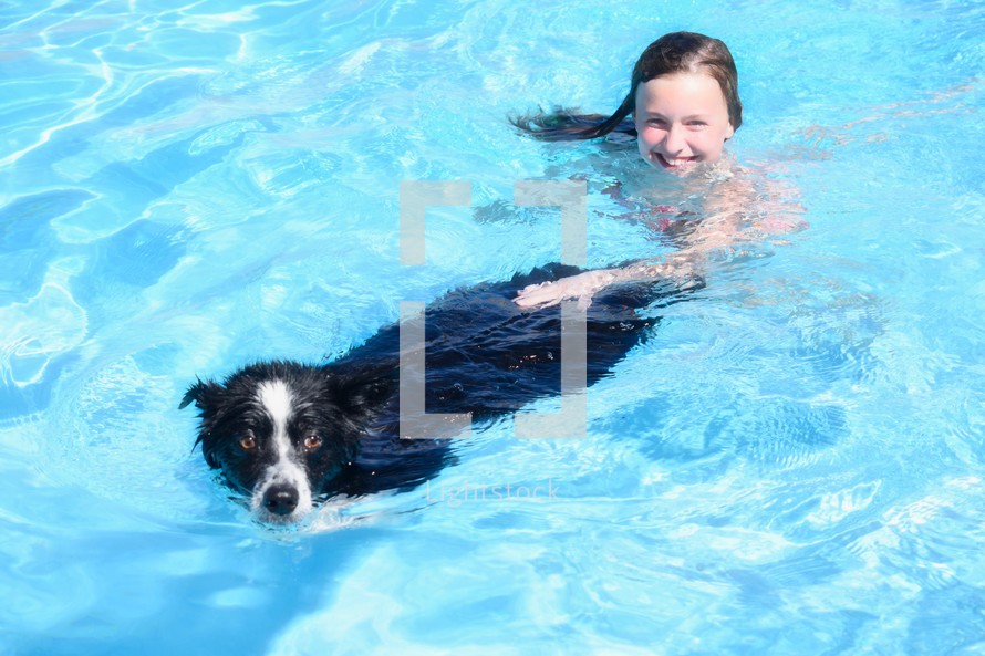 a girl and a dog swimming in a pool 