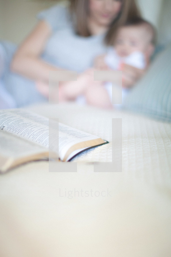 Mother holding daughter with open Bible.