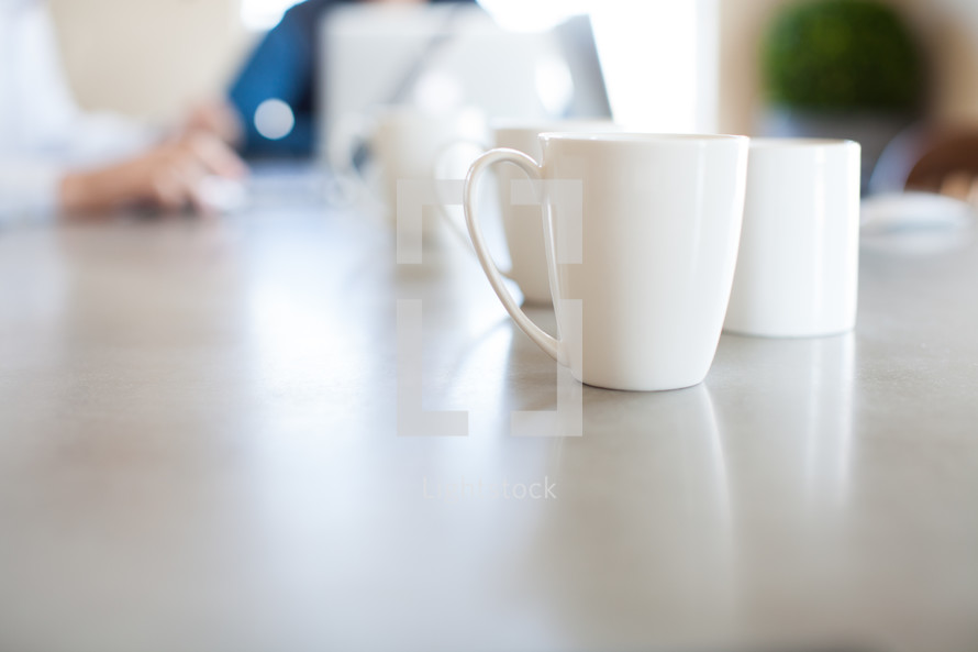 coffee mugs on a conference table 