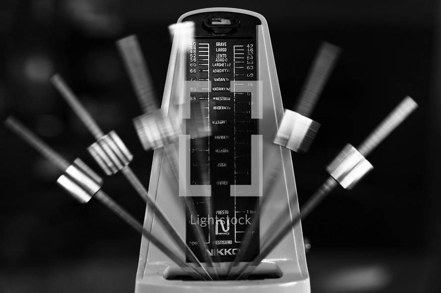 Metronome in motion, in black-and-white.