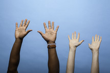 raised hands against a blue background 