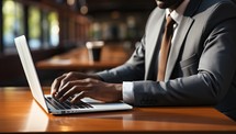 Businessman using laptop at table in cafe, closeup of hands