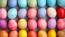 Colorful Easter eggs in a row, vibrant pastel palette with speckled patterns