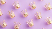 Golden crowns on a purple background. Concept of royalty, luxury, and power.