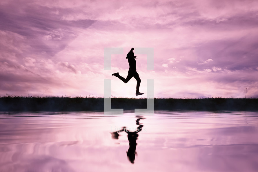 man jumping over a pond with a sunset background