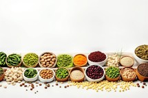 Variety of legumes in bowls on white background, top view