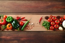 Fresh vegetables and spices on wooden cutting board. Top view with copy space