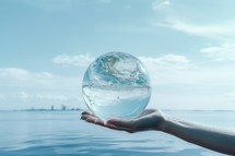 Planet Earth in human hand on blue sky background. Global warming concept.
