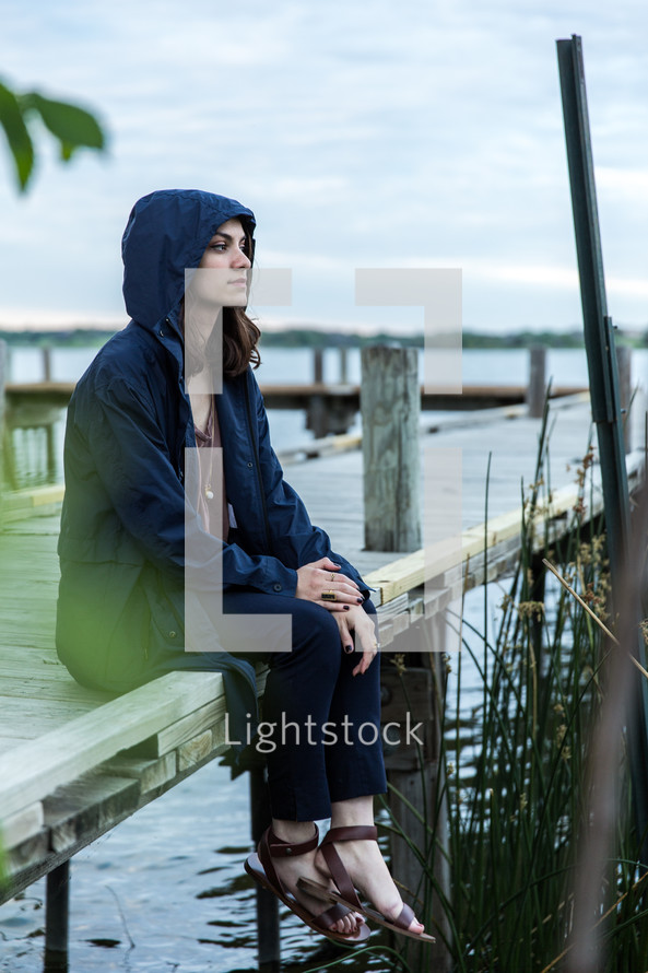 young woman sitting on a dock 
