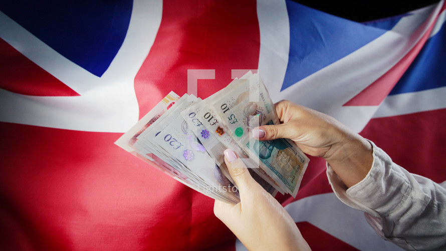 UK flag background. Woman counting GBP money pounds sterling.