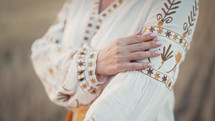 Ukrainian woman showing embroidery ornament, beautiful details of vyshyvanka shirt. National costume - embroidered shirt, texture, design, folk, handmade craft needlework
