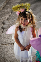 a girl child dressed as an angel in a live nativity scene 