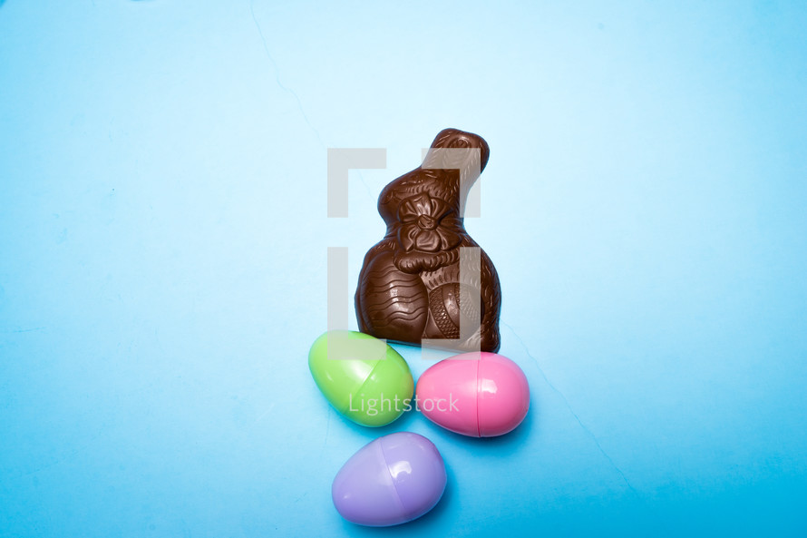 Chocolate Easter rabbit and Easter eggs over a blue background 