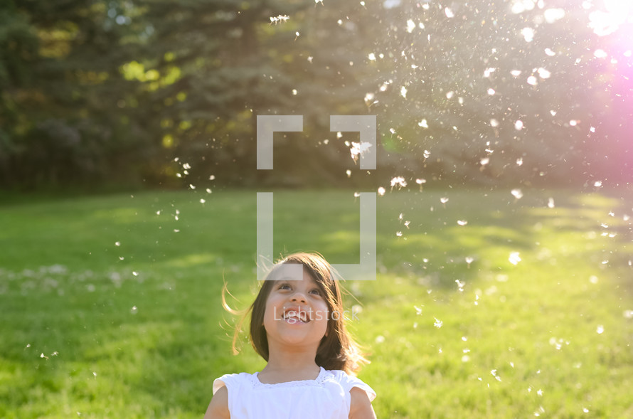 a little girl playing in a sprinkler in the grass 