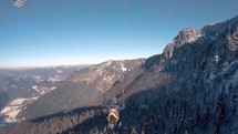 Paragliding flight above winter forest mountains nature, Freedom fly adrenaline adventure Follow cam
