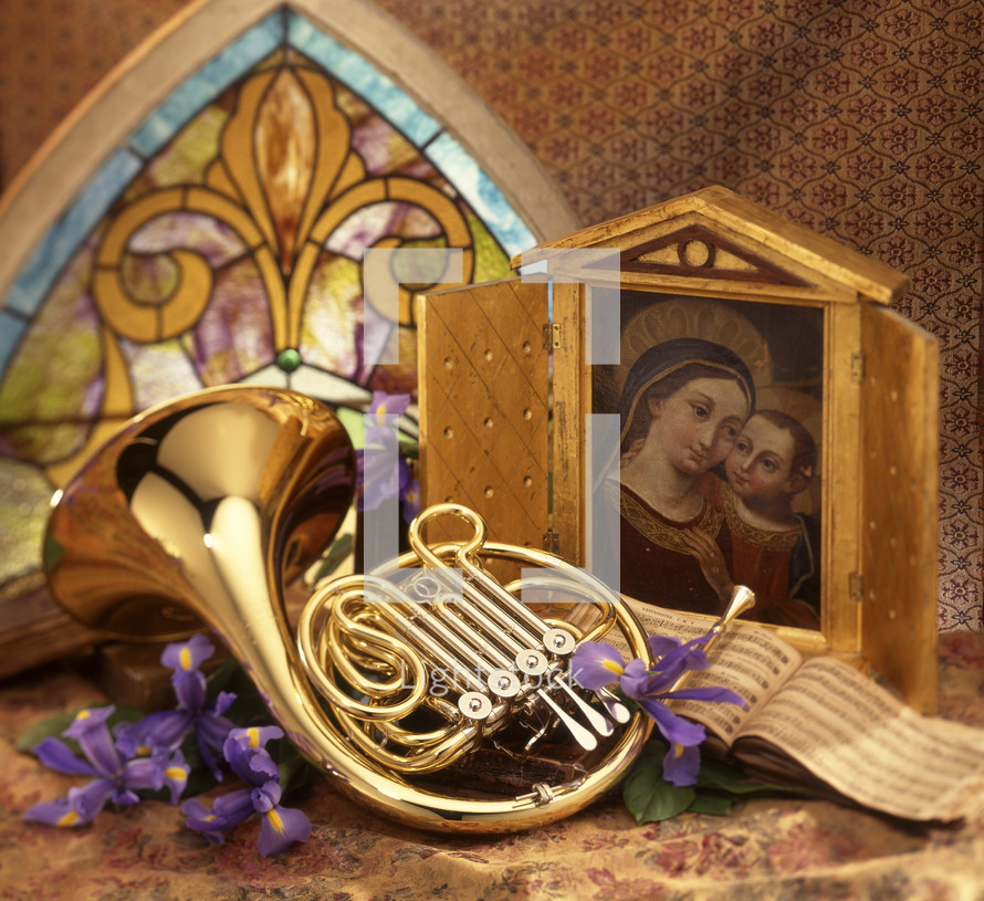 a french horn and painting of Mary and baby Jesus 