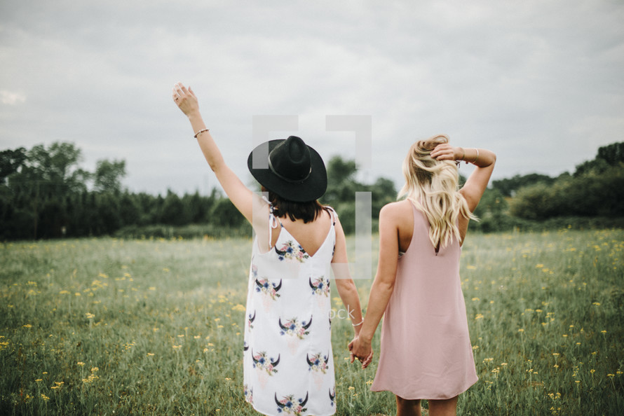 women holding hands in a field 