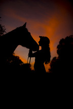 silhouette of a woman with her horse 