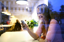 Young woman sitting in a restaurant using mobile