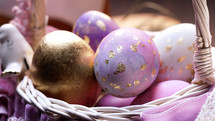 Beautiful Easter - colorful violet and golden eggs in woven basket. Craft holiday food decoration. Tasty religion symbol of spring, festive time. High quality
