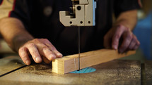 Handwork, carpentry concept, woodworking. Carpenter working in in factory atelier. Joiner labourer cuts wooden plank on jigsaw machine.