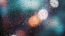 Close up view of water drops falling on glass. Rain running down on window. Rainy season, autumn. Raindrops trickle down, grey sky