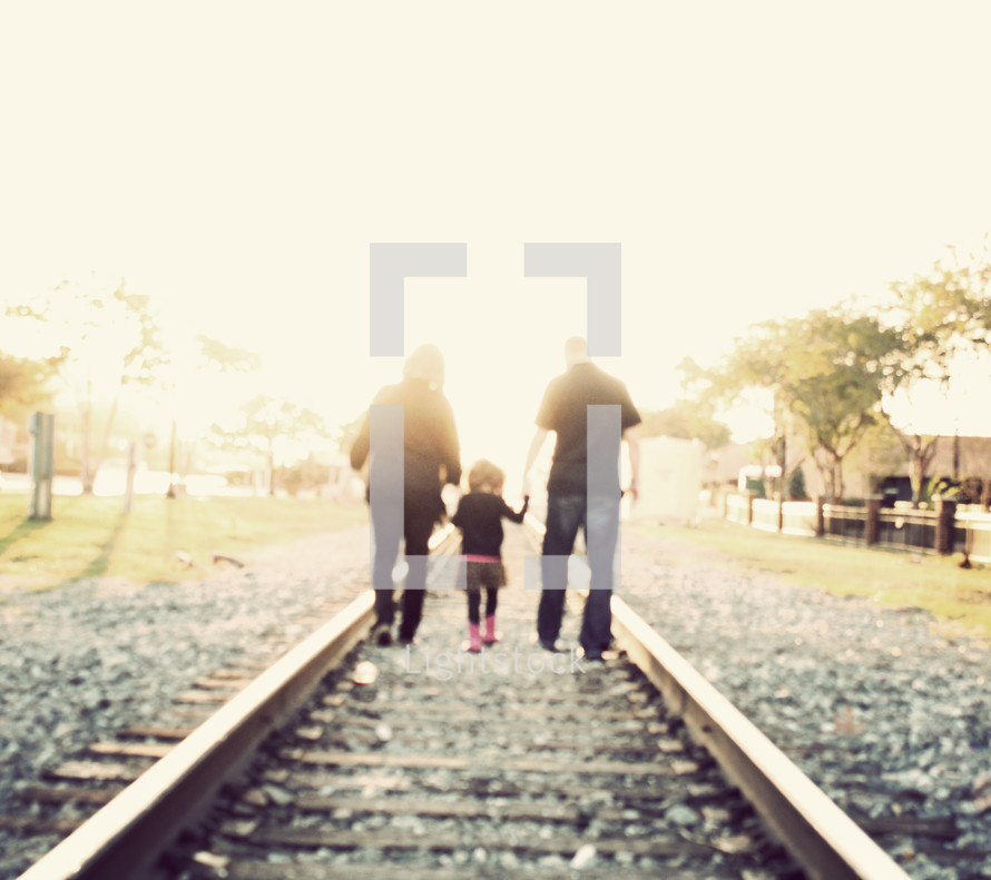 family walking on railroad tracks 
