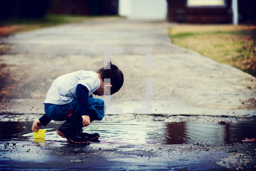 boy child playing in a puddle 