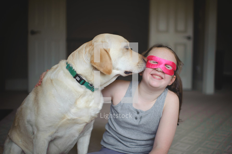 a child in a mask and her dog 