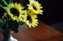 vase of sunflowers on a wooden table 