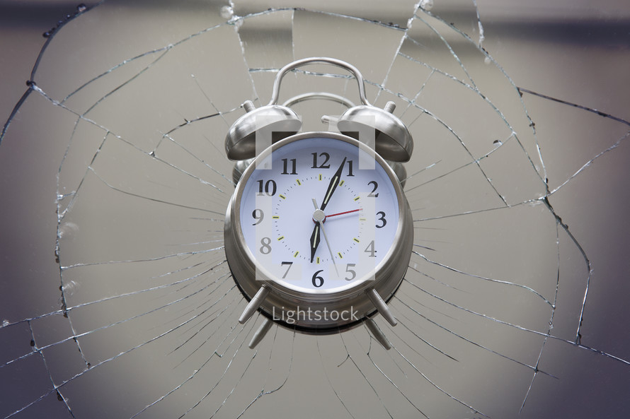 alarm clock on top of broken glass.