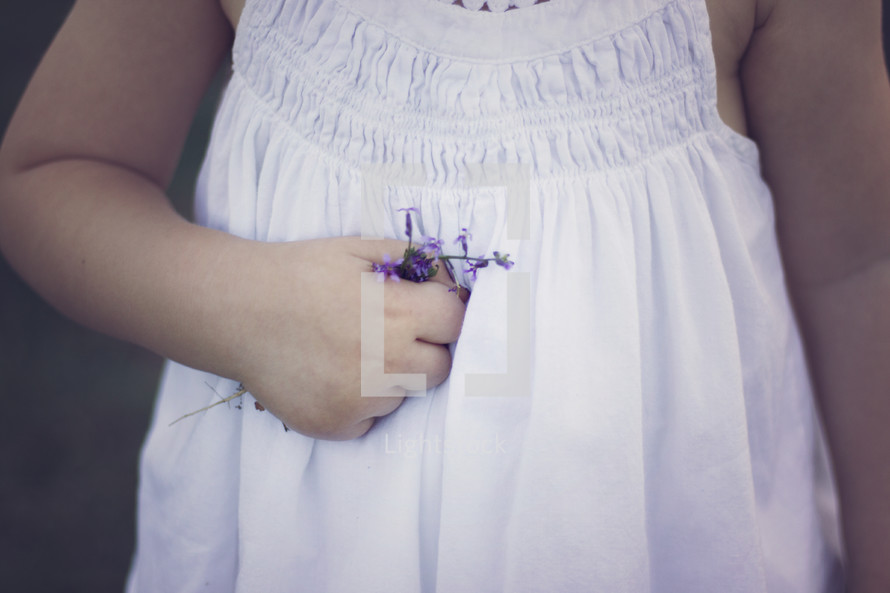 girl holding a tiny purple flower 