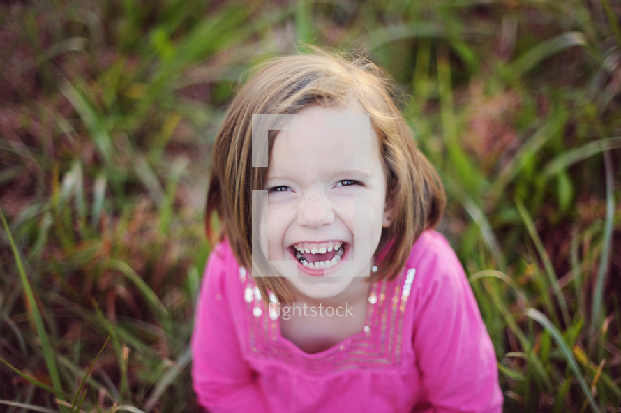 happy girl child sitting in grass