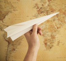 paper airplane in front of a map 