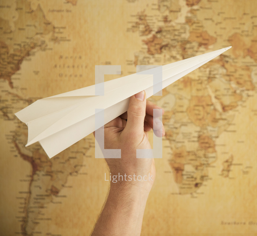 paper airplane in front of a map 