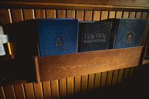 Hymnals and a Bible in the back of a pew