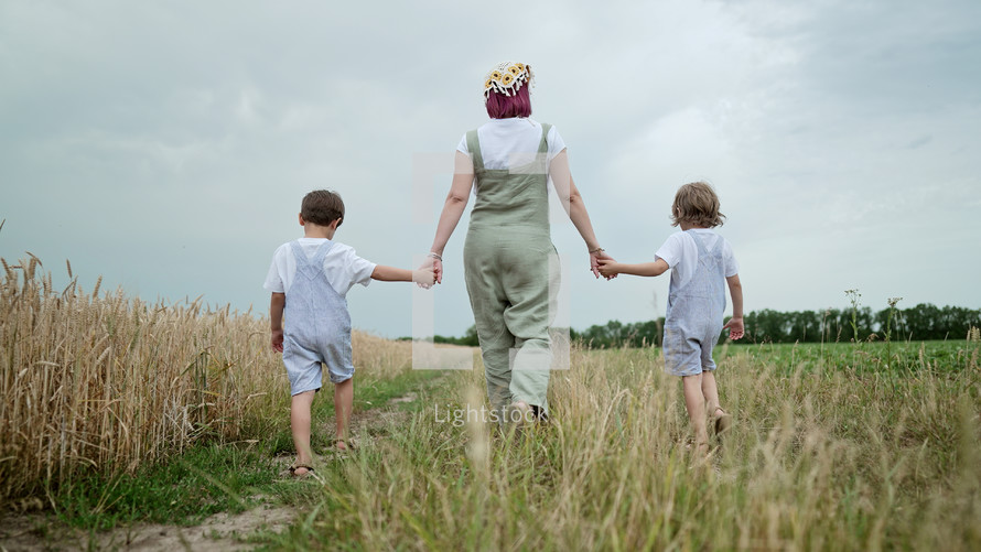 Mom and sons walking in a field